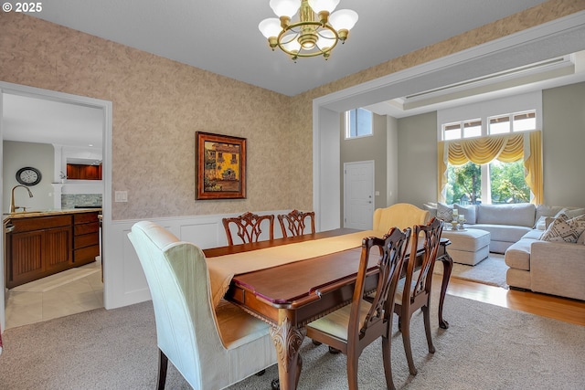 23836 SW Warbler Pl, Sherwood, OR 97140 - dining area featuring a chandelier, wallpapered walls, light carpet, and wainscoting