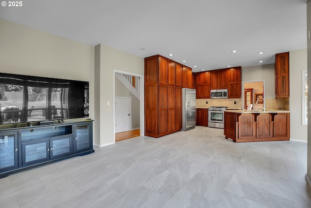 23836 SW Warbler Pl, Sherwood, OR 97140 - kitchen featuring stainless steel appliances, decorative backsplash, light countertops, a kitchen bar, and a peninsula