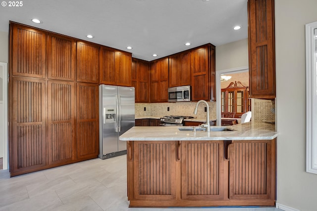 23836 SW Warbler Pl, Sherwood, OR 97140 - kitchen with appliances with stainless steel finishes, a sink, a peninsula, decorative backsplash, and recessed lighting