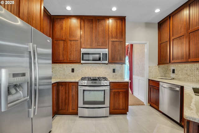 23836 SW Warbler Pl, Sherwood, OR 97140 - kitchen featuring stainless steel appliances, decorative backsplash, light stone countertops, recessed lighting, and brown cabinets