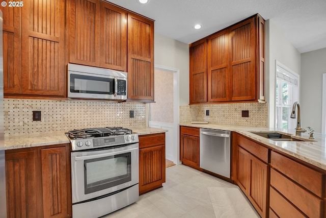 23836 SW Warbler Pl, Sherwood, OR 97140 - kitchen with stainless steel appliances, a sink, light stone countertops, tasteful backsplash, and recessed lighting
