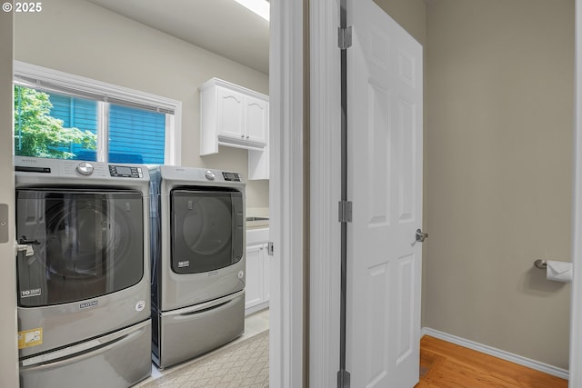 23836 SW Warbler Pl, Sherwood, OR 97140 - laundry area with separate washer and dryer, cabinet space, light wood-type flooring, and baseboards