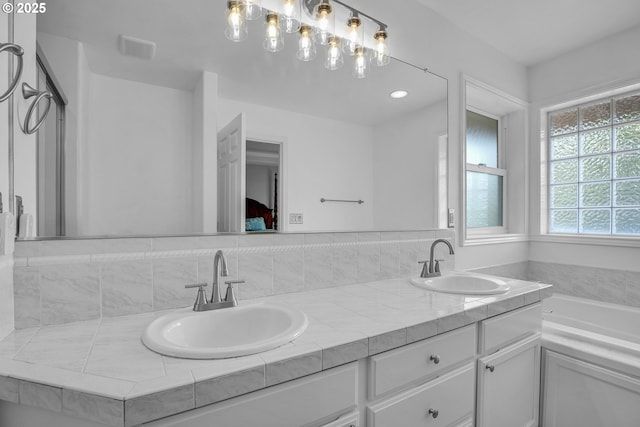 23836 SW Warbler Pl, Sherwood, OR 97140 - bathroom with double vanity, a bathtub, and tasteful backsplash