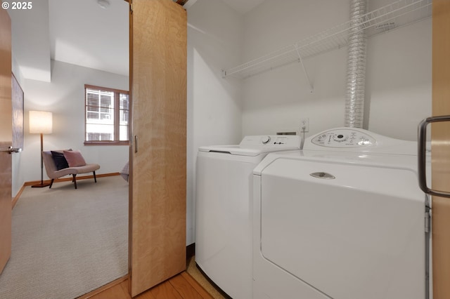 laundry room featuring separate washer and dryer and light carpet