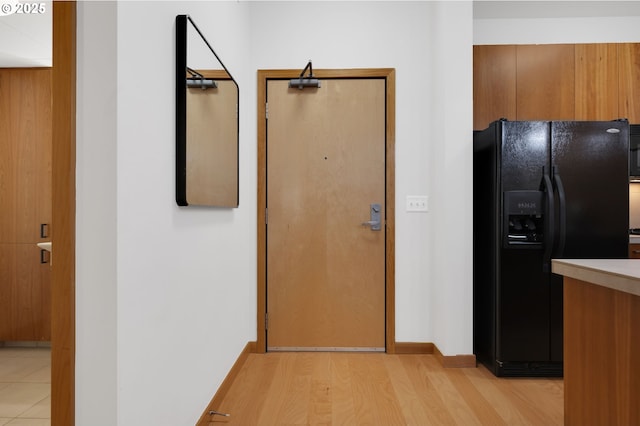 kitchen featuring black fridge and light hardwood / wood-style flooring