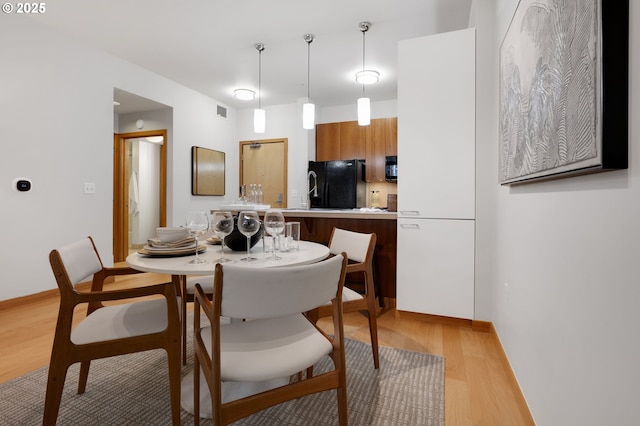 dining space with light hardwood / wood-style flooring