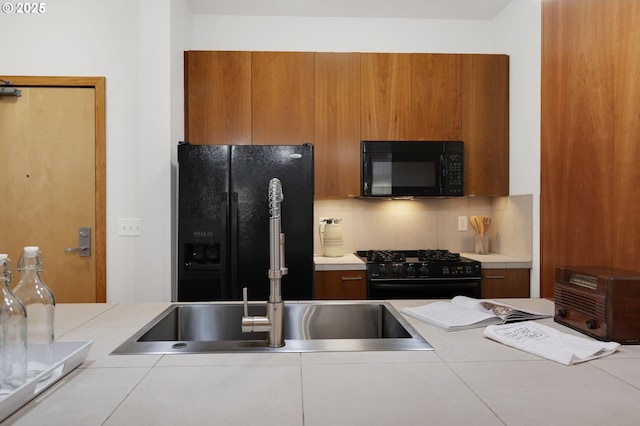 kitchen with black appliances, backsplash, and sink