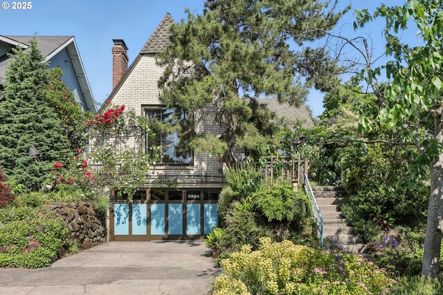 2804 NE 46th Ave, Portland, OR 97213 - rear view of house with stairway, driveway, a chimney, and roof with shingles