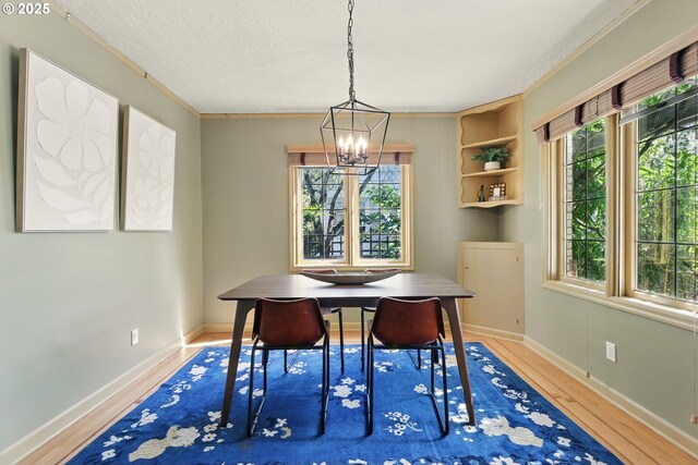 2804 NE 46th Ave, Portland, OR 97213 - dining space with a chandelier, wood finished floors, crown molding, and baseboards