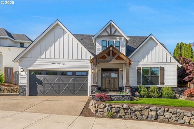 view of front facade with board and batten siding, driveway, roof with shingles, an attached garage, and stone siding
