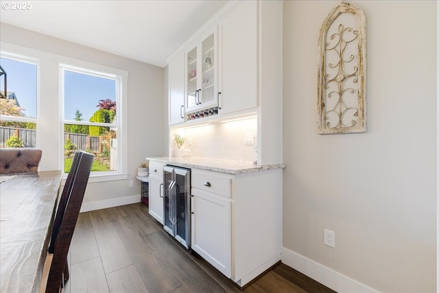 bar featuring baseboards, a dry bar, dark wood-style flooring, and wine cooler