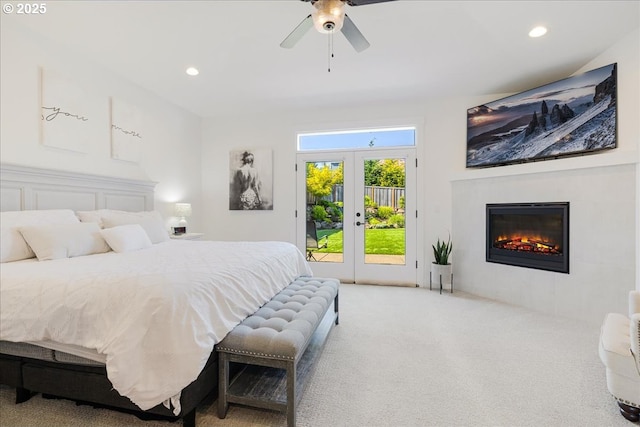 bedroom featuring french doors, a glass covered fireplace, access to outside, carpet flooring, and recessed lighting