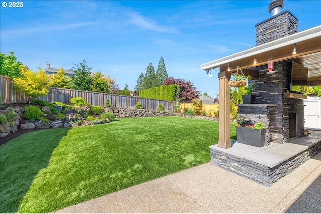 view of yard featuring an outdoor stone fireplace, a fenced backyard, and a patio area