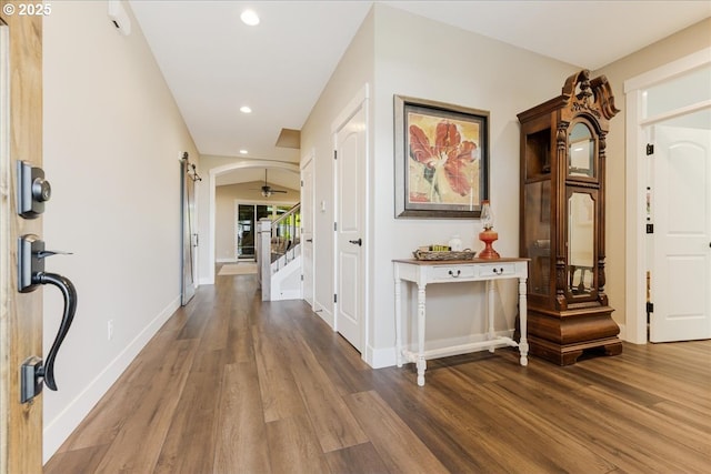 foyer with stairs, wood finished floors, baseboards, recessed lighting, and arched walkways