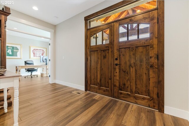 entrance foyer with recessed lighting, baseboards, visible vents, and wood finished floors