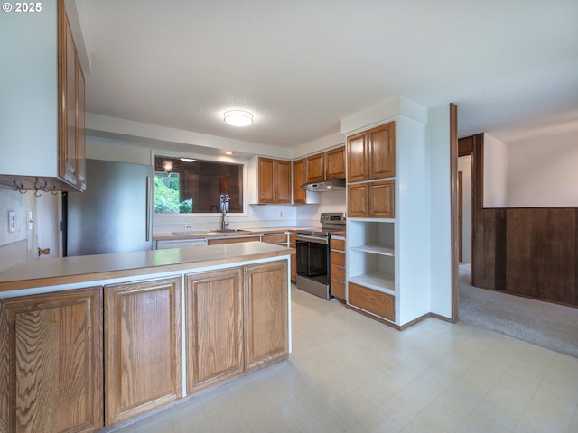 2830 Capital Dr, Eugene, OR 97403 - kitchen with stainless steel appliances, under cabinet range hood, a peninsula, light countertops, and brown cabinetry