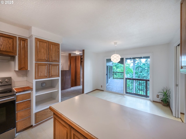 2830 Capital Dr, Eugene, OR 97403 - kitchen with electric stove, brown cabinets, a textured ceiling, light countertops, and decorative light fixtures