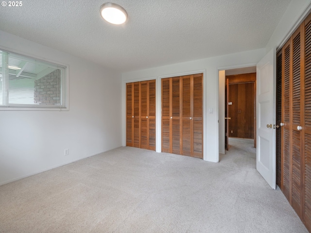2830 Capital Dr, Eugene, OR 97403 - unfurnished bedroom featuring two closets, carpet flooring, and a textured ceiling