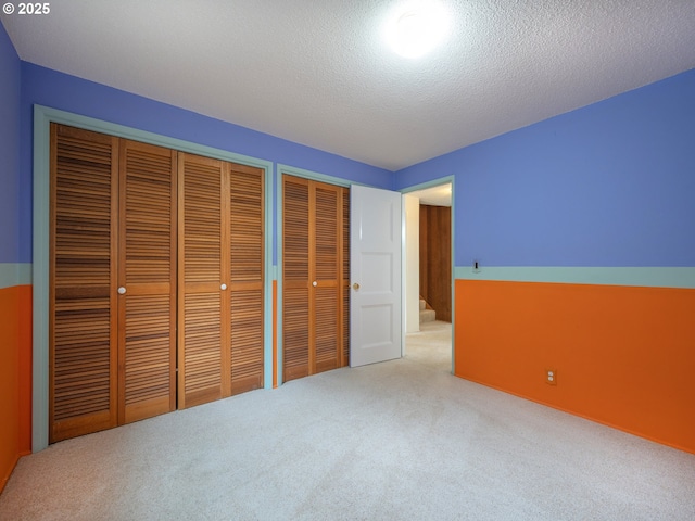 2830 Capital Dr, Eugene, OR 97403 - unfurnished bedroom featuring carpet floors, two closets, and a textured ceiling