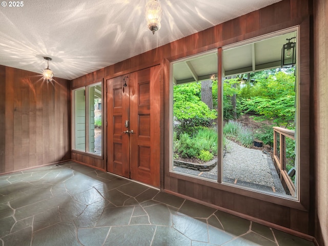 2830 Capital Dr, Eugene, OR 97403 - foyer featuring stone floors, healthy amount of natural light, and wooden walls