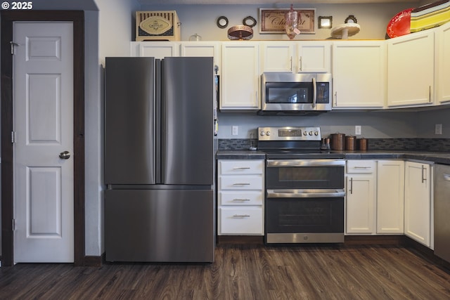 kitchen featuring stainless steel appliances, dark wood-type flooring, dark countertops, and white cabinets