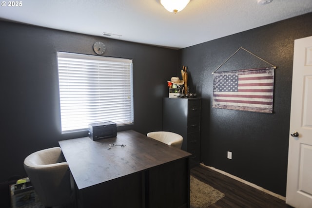 home office with visible vents, a textured wall, and wood finished floors