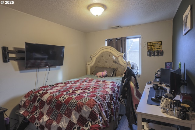 bedroom with a textured ceiling and visible vents