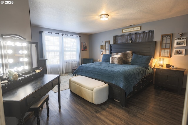 bedroom featuring a textured ceiling, visible vents, and wood finished floors