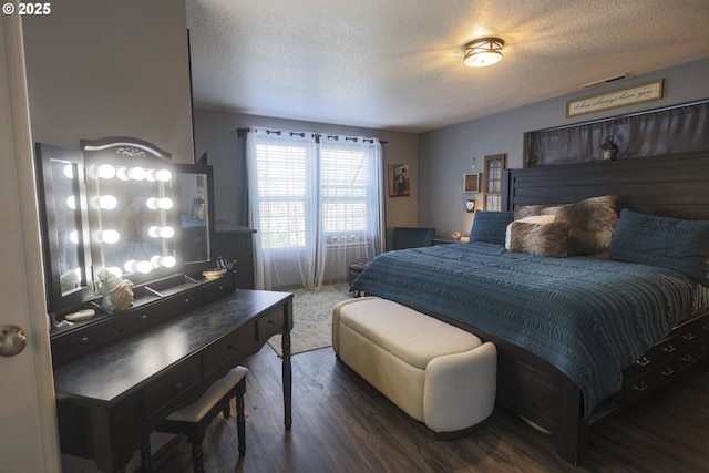 bedroom with a textured ceiling, visible vents, and wood finished floors