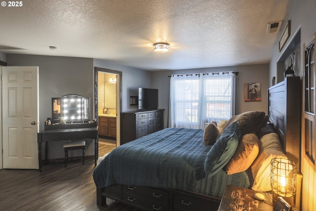 bedroom featuring a textured ceiling, connected bathroom, visible vents, and wood finished floors