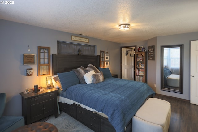 bedroom with a textured ceiling and wood finished floors