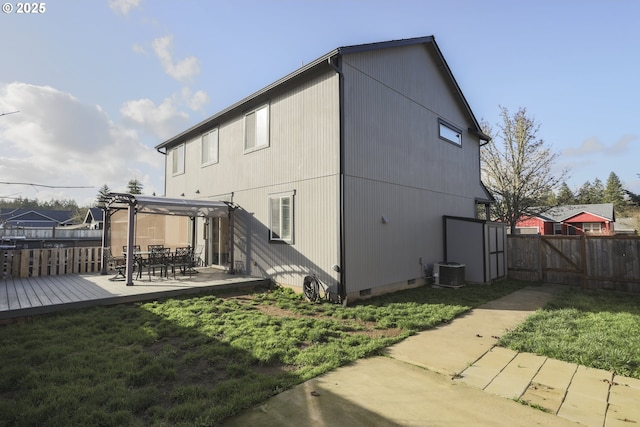 rear view of house featuring a lawn, crawl space, fence, a wooden deck, and central AC