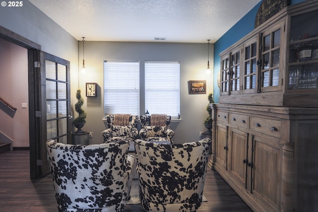 dining space featuring stairs, a textured ceiling, and dark wood-style flooring