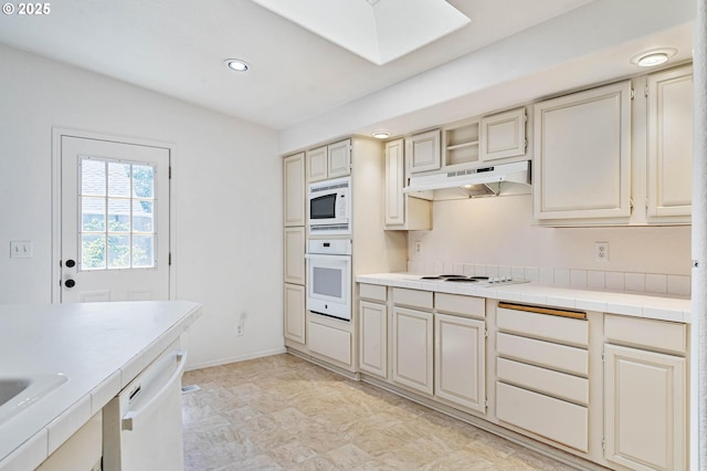 9341 N Pier Park Pl, Portland, OR 97203 - kitchen with white appliances, under cabinet range hood, cream cabinetry, recessed lighting, and a skylight