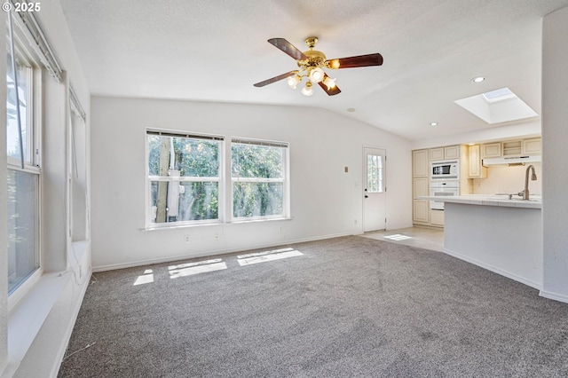 9341 N Pier Park Pl, Portland, OR 97203 - unfurnished living room with a skylight, light colored carpet, lofted ceiling, ceiling fan, and recessed lighting