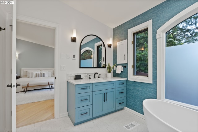 17595 Kelok Rd, Lake Oswego, OR 97034 - bathroom featuring ensuite bath, vanity, a freestanding tub, baseboards, and wallpapered walls