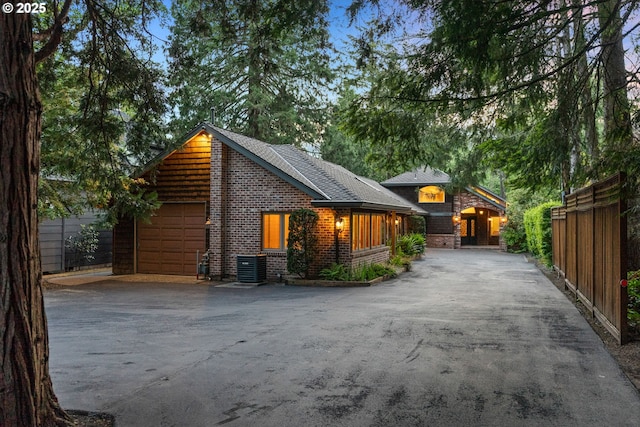 17595 Kelok Rd, Lake Oswego, OR 97034 - view of property exterior featuring driveway, central AC unit, brick siding, and an attached garage