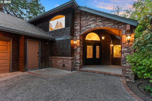 17595 Kelok Rd, Lake Oswego, OR 97034 - exterior entry at dusk with brick siding and roof with shingles