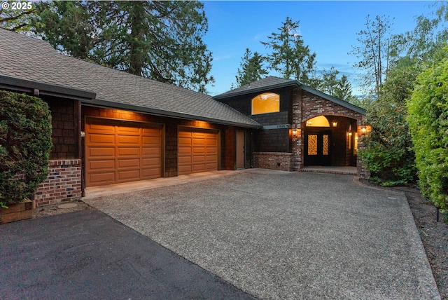 17595 Kelok Rd, Lake Oswego, OR 97034 - view of front of house with brick siding, driveway, an attached garage, and a shingled roof