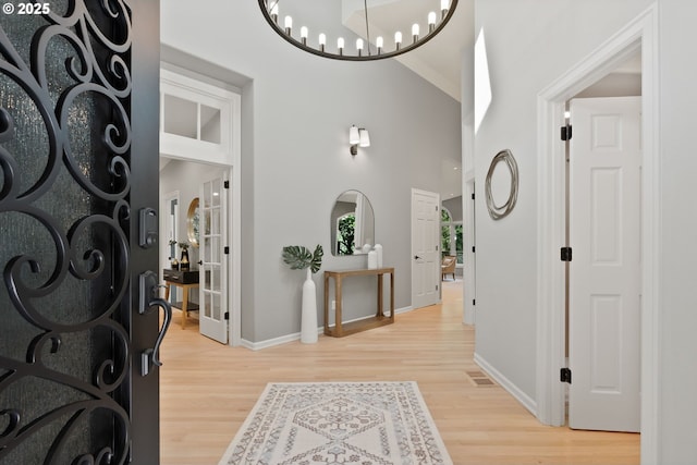 17595 Kelok Rd, Lake Oswego, OR 97034 - entrance foyer with baseboards, light wood-style flooring, a chandelier, and a towering ceiling