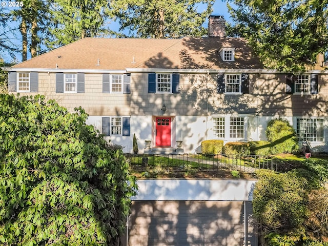 view of front of property with a fenced front yard and a chimney