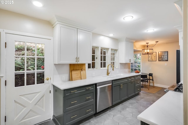 kitchen with a sink, white cabinets, stainless steel dishwasher, and light countertops