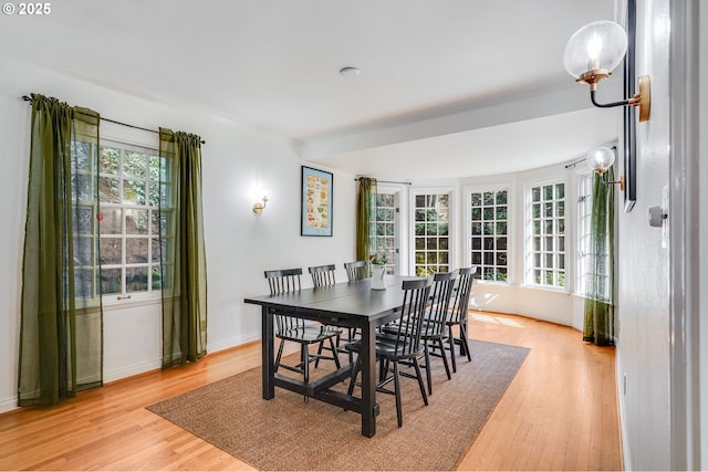 dining area featuring baseboards and light wood finished floors