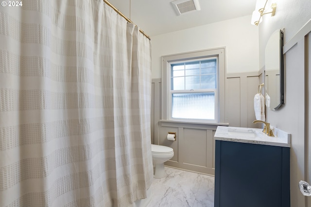 full bath featuring vanity, toilet, a wainscoted wall, marble finish floor, and visible vents