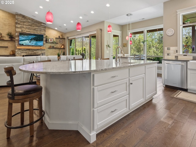 kitchen featuring dark wood-type flooring, a sink, lofted ceiling, and dishwasher