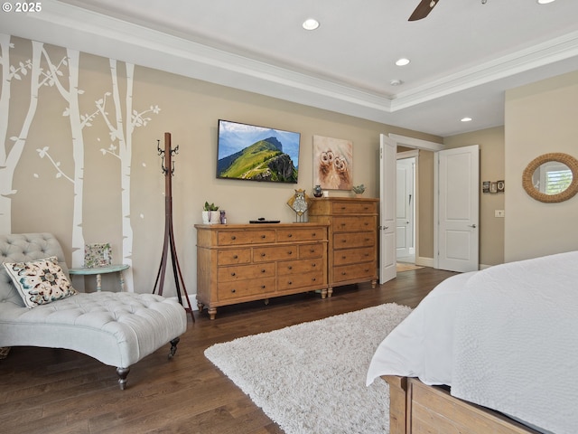 bedroom with ceiling fan, dark wood finished floors, ornamental molding, a tray ceiling, and recessed lighting