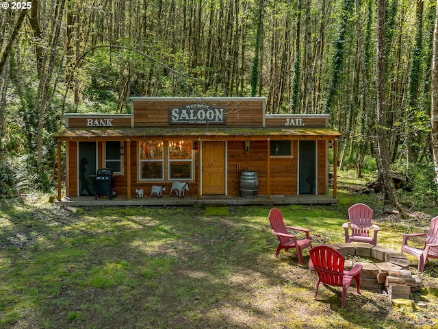 view of outdoor structure featuring a view of trees and an outdoor fire pit
