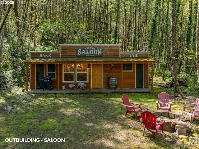 view of outbuilding featuring a wooded view and a fire pit