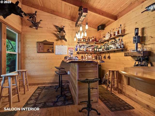 bar featuring a dry bar, vaulted ceiling with beams, wood-type flooring, and wood walls
