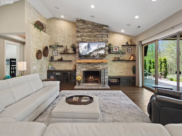 living area with a stone fireplace, recessed lighting, dark wood finished floors, and high vaulted ceiling